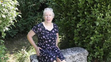 Naughty granny playing in the garden with her pussy